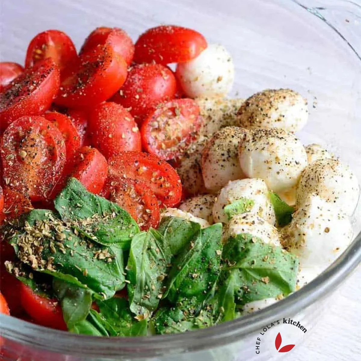 Tomato Mozzarella Salad seasoned with salt, black pepper and oregano in a bowl