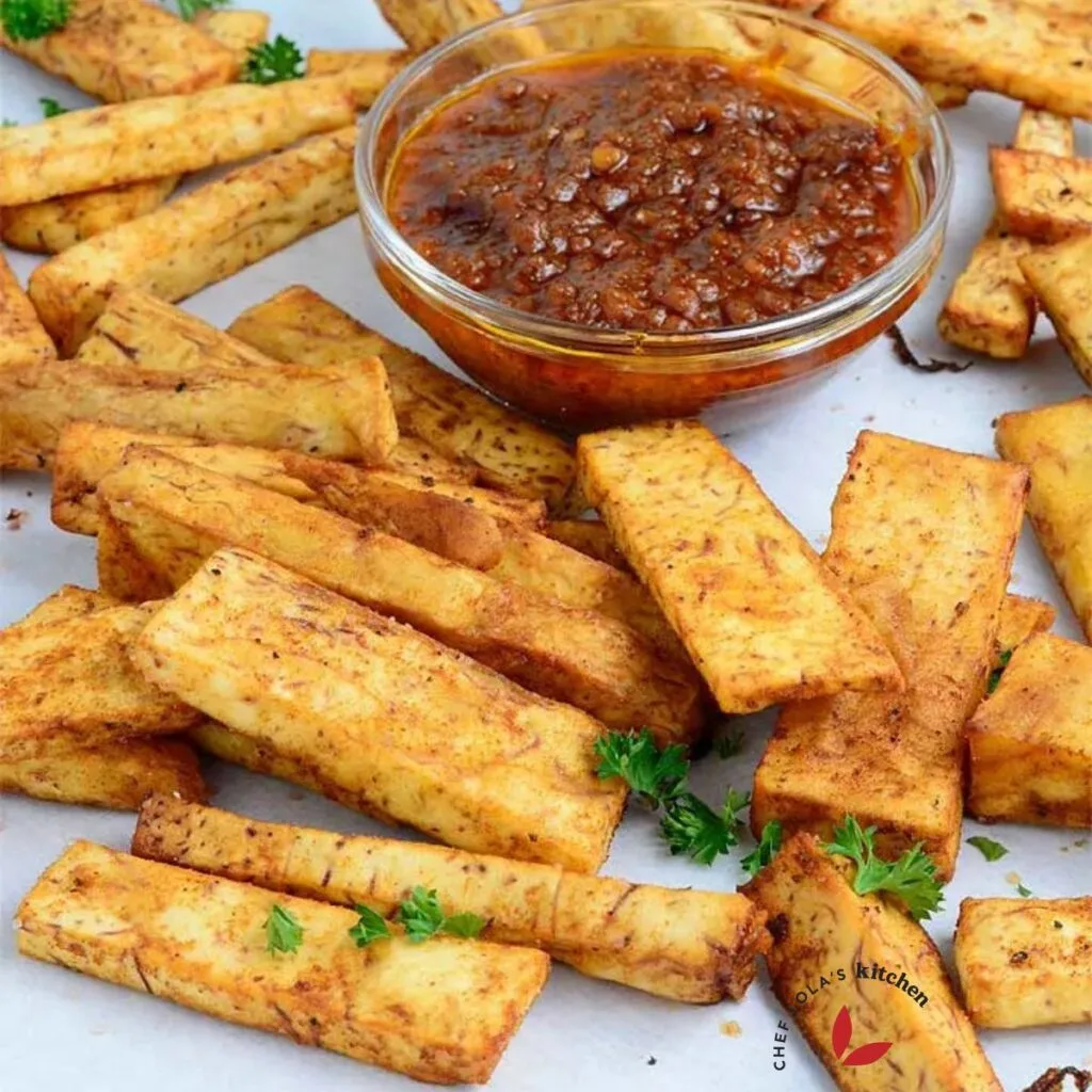Taro root fries on a parchment paper with pepper sauce