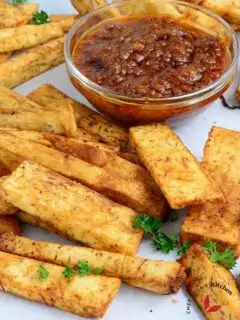 Taro root fries on a parchment paper with pepper sauce