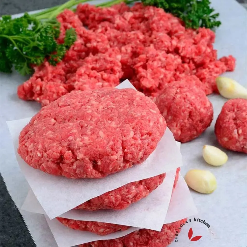 Homemade ground beef in a food processor shaped into patties