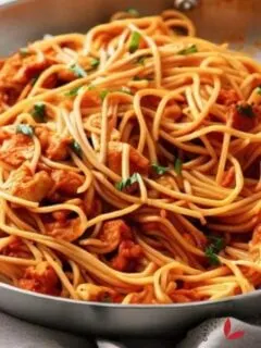 A delicious pot of chicken spaghetti garnished with parsley