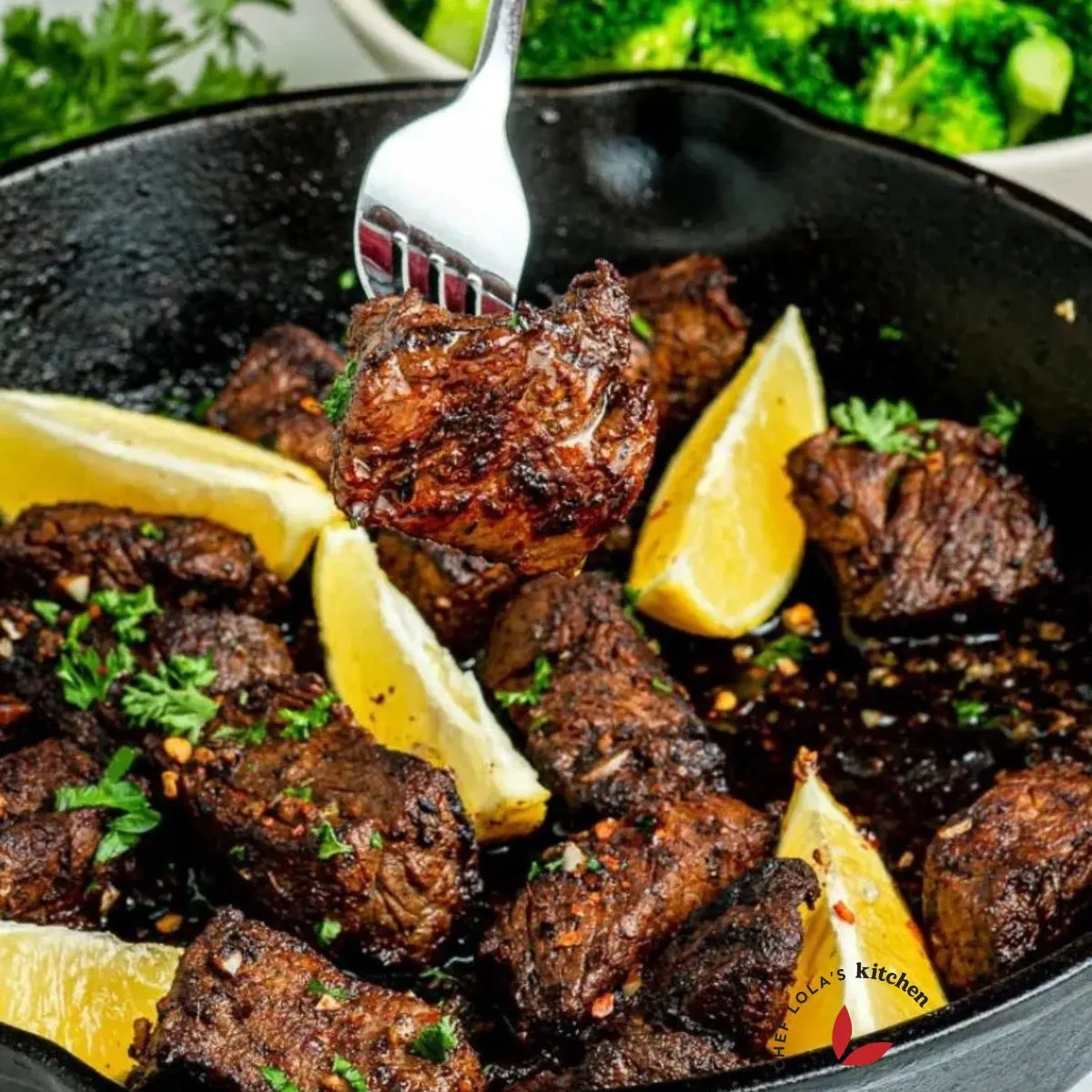 Steak bites garnished with lemon edges and parsley.